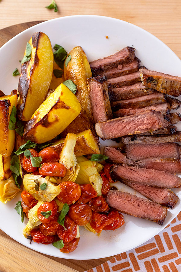 Greek Sheet-Pan KC Strip Steak with Roasted Tomatoes, Artichokes & Fingerlings